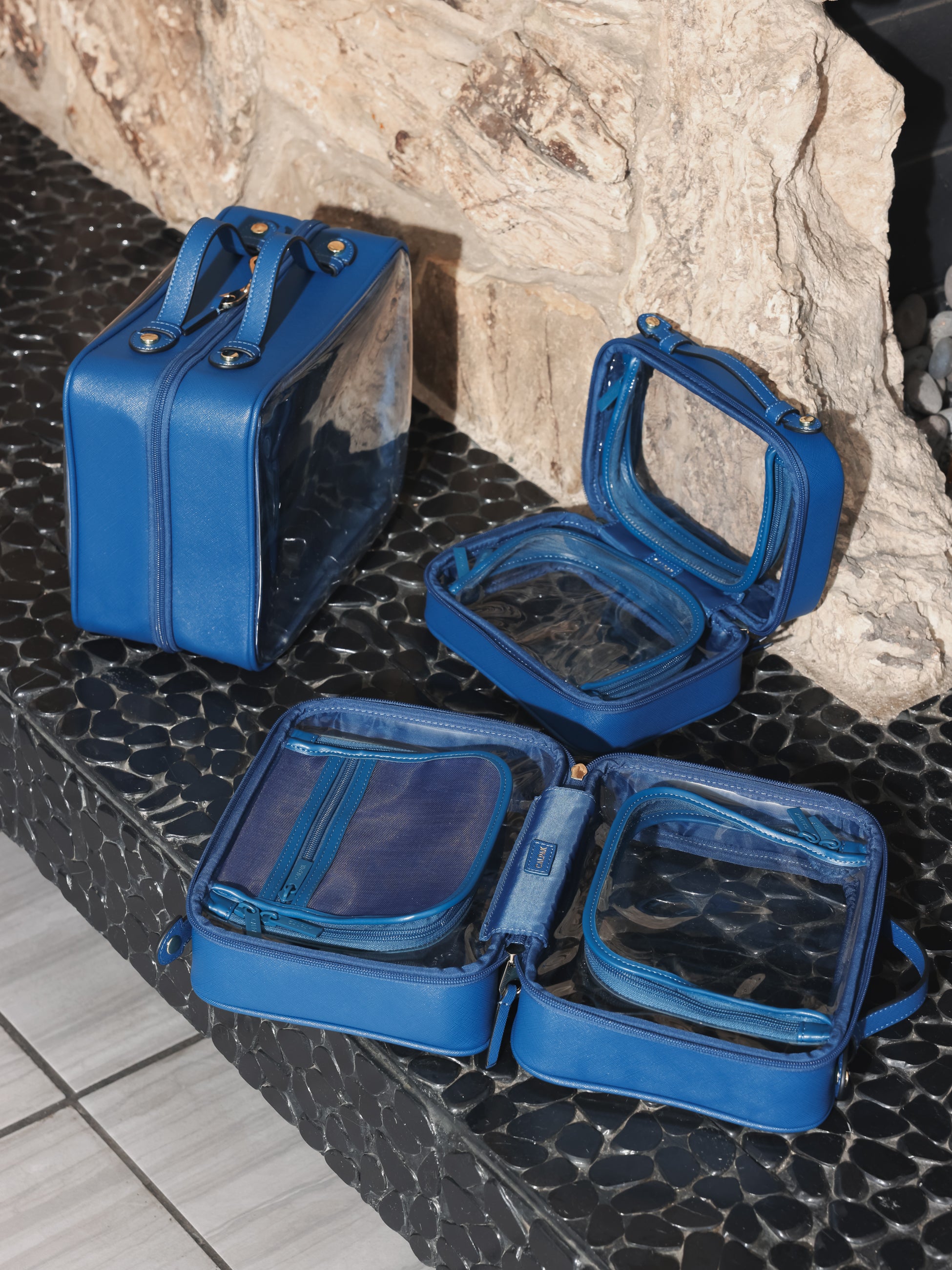 CALPAK dark blue clear makeup cases with zippered compartments in small, medium and large sizes