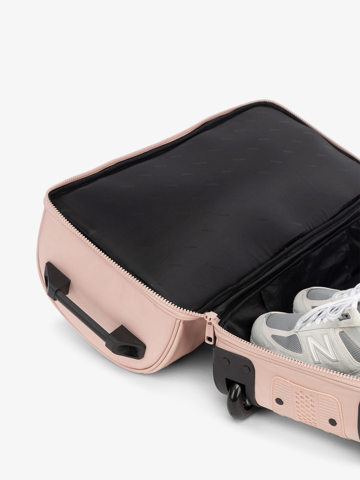 CALPAK Stevyn Rolling Duffle interior of shoe compartment in pink sand