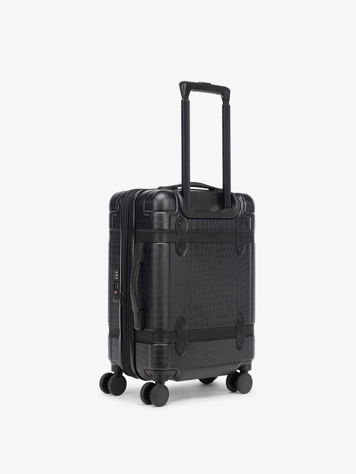 black hard shell CALPAK TRNK suitcase with four 360 wheels in vintage trunk style carry-on luggage