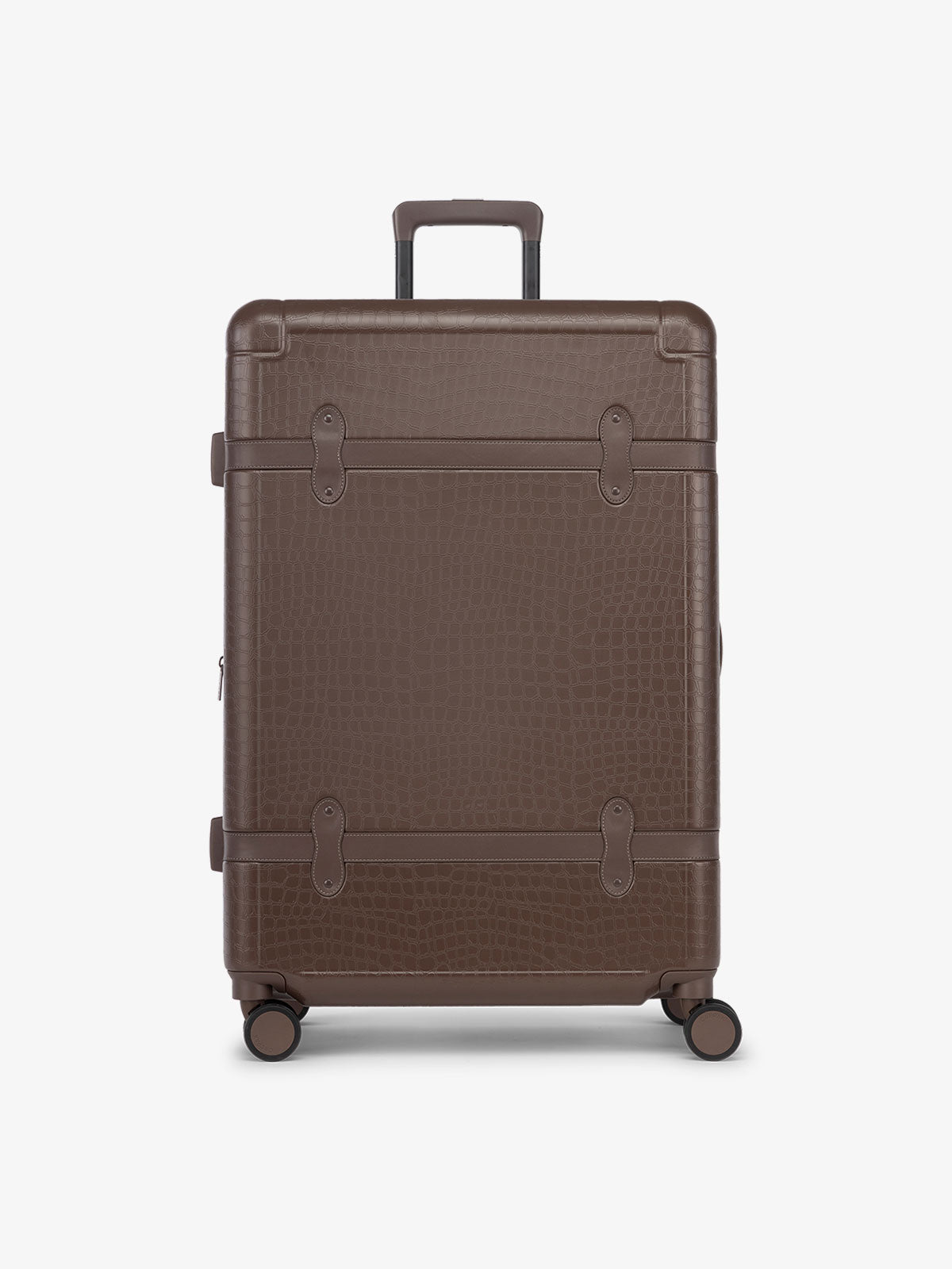 CALPAK TRNK large suitcase with hard shell exterior and four 360 spinner wheels in espresso vintage trunk style
