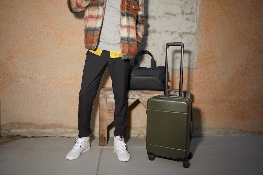 male model with CALPAK Hue carry on suitcase