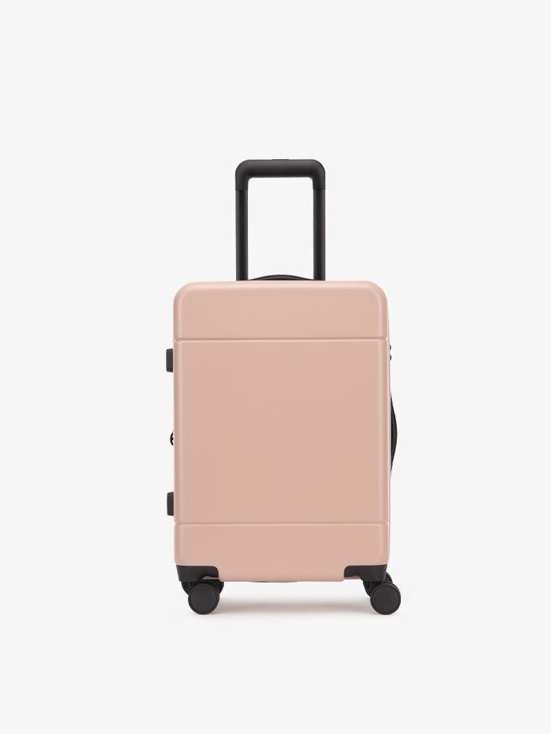 CALPAK Hue hard shell rolling carry-on luggage in pink sand color