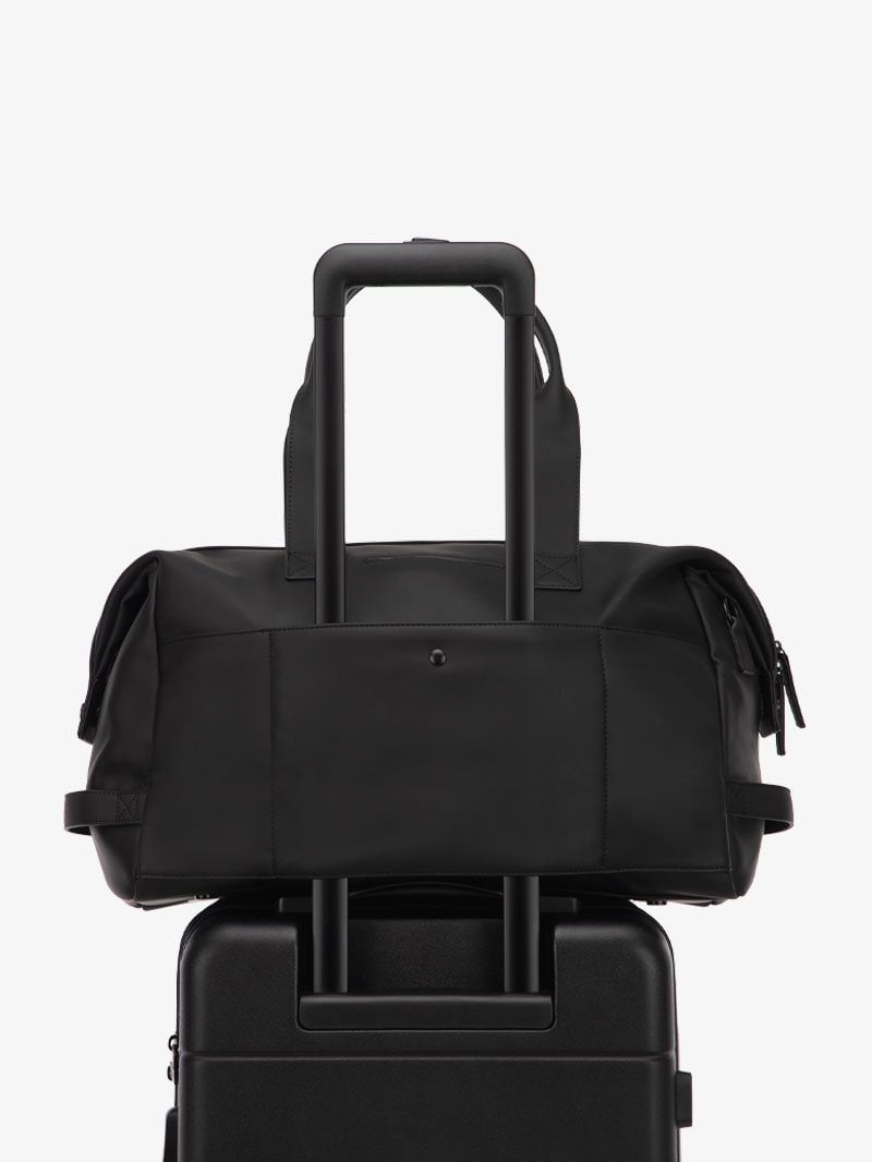 black CALPAK Hue duffel bag with luggage trolley sleeve