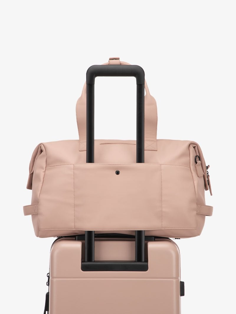 pink CALPAK Hue duffel bag with luggage trolley sleeve
