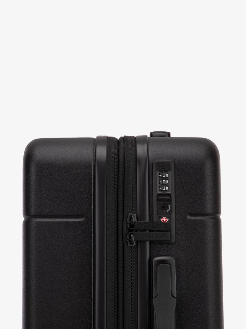 large black CALPAK Hue checked luggage with built in TSA lock