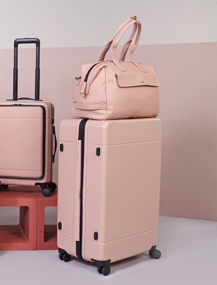 large hardside polycarbonate suitcase in pink sand color with duffel and carry on from CALPAK Hue luggage collection