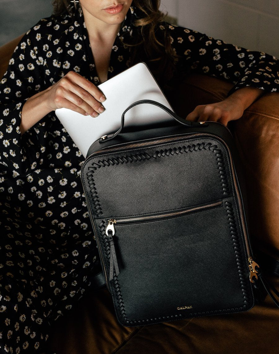 female model with black CALPAK Kaya laptop backpack for women