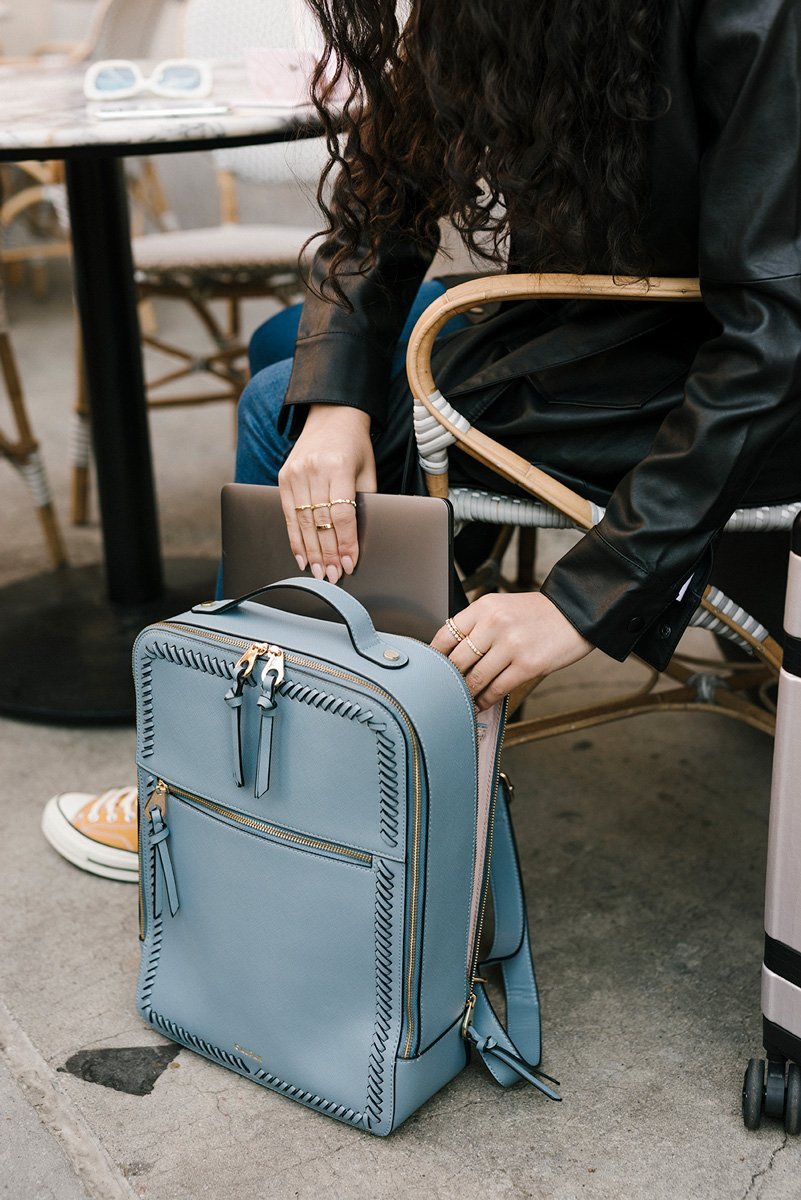 model with CALPAK Kaya laptop backpack in blue bell color