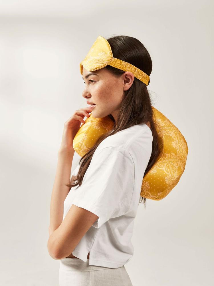 CALPAK travel eye mask and neck pillow in luxurious yellow silk