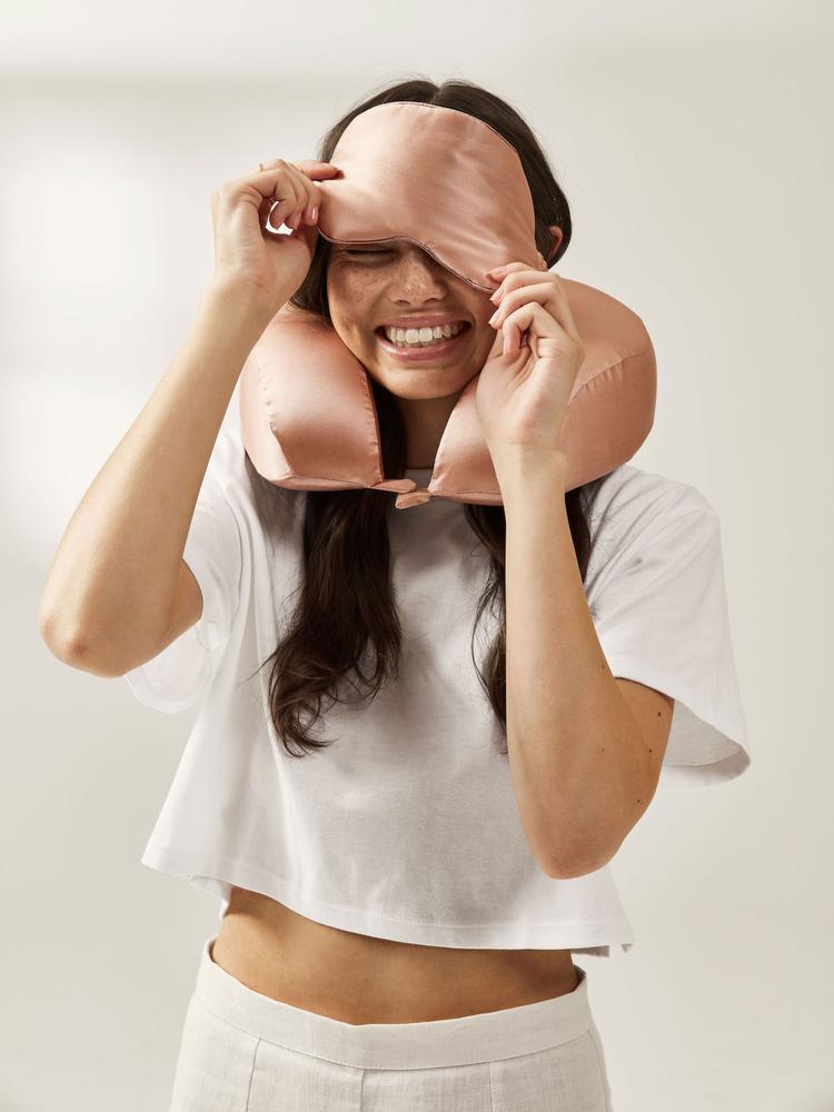 model with CALPAK rose gold silk travel set